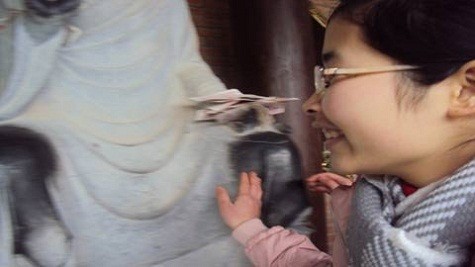 Một bạn nữ hào hứng khi tận tay sờ được vào tượng Phật để cầu may như bao người khác.